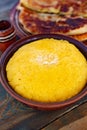 Polenta is a dish made from corn flour, served with a book and cheese.