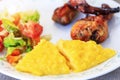 Polenta or Mamaliga, baked chicken legs and salad in fancy plate. Traditional food and culinary culture specific for Balkan Royalty Free Stock Photo