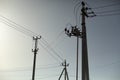 Poles with electrical wires. Silhouettes of communication racks. High voltage lines. Energy transfer