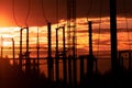 Poles at a power plant at sunset as a background Royalty Free Stock Photo