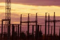 Poles at a power plant at sunset as a background Royalty Free Stock Photo