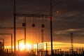 Poles at a power plant at sunset as a background Royalty Free Stock Photo