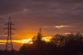 Poles at a power plant at sunset as a background Royalty Free Stock Photo