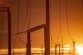 Poles at a power plant at sunset as a background Royalty Free Stock Photo