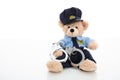 Cute teddy in policeman uniform and handcuffs against white background