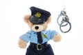 Cute teddy in policeman uniform and handcuffs isolated against white background