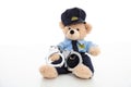 Cute teddy in policeman uniform and handcuffs isolated against white background