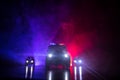 Police car chasing a car at night with fog background. 911 Emergency response police car speeding to scene of crime. Selective foc Royalty Free Stock Photo