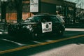 Police car cruises drive down marked Ford Explorer on 17th Avenue  SW in Calgary, Alberta, Canada Royalty Free Stock Photo