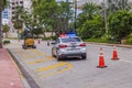 Police car with its roof lights on standing on one of streets of Miami Beach, which is restricted for traffic Royalty Free Stock Photo