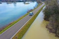 A police car patrols an asphalt country road during floods. Flood disaster in winter.