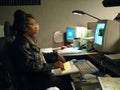 A police dispatcher using a computer to dispatch calls for help r