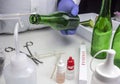 Police expert gets blood sample from a green glass bottle in Criminalistic Lab