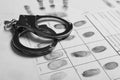 Police handcuffs and criminal fingerprints card Royalty Free Stock Photo