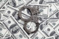 Police handcuffs lie on a lot of dollar bills. The concept of illegal possession of money, illegal transactions with US dollars. Royalty Free Stock Photo