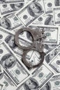 Police handcuffs lie on a lot of dollar bills. The concept of illegal possession of money, illegal transactions with US dollars. Royalty Free Stock Photo