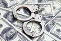 Police handcuffs lie on a lot of dollar bills. The concept of illegal possession of money, illegal transactions with US dollars. Royalty Free Stock Photo