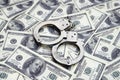 Police handcuffs lie on a lot of dollar bills. The concept of illegal possession of money, illegal transactions with US dollars. Royalty Free Stock Photo