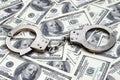 Police handcuffs lie on a lot of dollar bills. The concept of illegal possession of money, illegal transactions with US dollars. Royalty Free Stock Photo