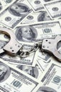 Police handcuffs lie on a lot of dollar bills. The concept of illegal possession of money, illegal transactions with US dollars. Royalty Free Stock Photo