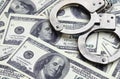 Police handcuffs lie on a lot of dollar bills. The concept of illegal possession of money, illegal transactions with US dollars. Royalty Free Stock Photo