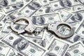 Police handcuffs lie on a lot of dollar bills. The concept of illegal possession of money, illegal transactions with US dollars. Royalty Free Stock Photo