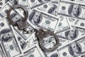 Police handcuffs lie on a lot of dollar bills. The concept of illegal possession of money, illegal transactions with US dollars. Royalty Free Stock Photo