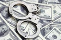 Police handcuffs lie on a lot of dollar bills. The concept of illegal possession of money, illegal transactions with US dollars. Royalty Free Stock Photo