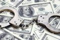 Police handcuffs lie on a lot of dollar bills. The concept of illegal possession of money, illegal transactions with US dollars. Royalty Free Stock Photo