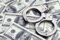 Police handcuffs lie on a lot of dollar bills. The concept of illegal possession of money, illegal transactions with US dollars. Royalty Free Stock Photo