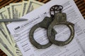 Police handcuffs lie on the tax form 1040. The concept of proble