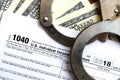 Police handcuffs lie on the tax form 1040. The concept of proble