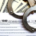 Police handcuffs lie on the tax form 1040. The concept of proble