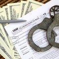 Police handcuffs lie on the tax form 1040. The concept of proble