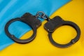 Police handcuffs lie on the Ukrainian flag.  Concept: Ukrainian justice, trial of criminals. Royalty Free Stock Photo