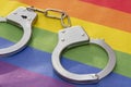 Police handcuffs rest on a colorful LGBT flag. Concept: criminalization, ban in Russia. Royalty Free Stock Photo