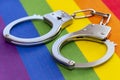 Police handcuffs rest on a colorful LGBT flag. Concept: criminalization, ban in Russia. Royalty Free Stock Photo