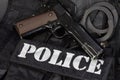 Police handgun with handcuffs on black uniform Royalty Free Stock Photo