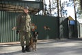 Police handler and his dog German shepherd standing in front of an entrance to Canine centre