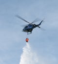 Police helicopter dropping water from bucket Royalty Free Stock Photo