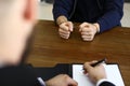 Police interrogating criminal in handcuffs at desk indoors