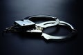 Police metal handcuffs on black background, close-up, selective focus