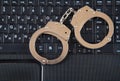 Police metal handcuffs and computer keyboard