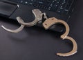 Police metal handcuffs and computer keyboard