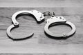 Police metal handcuffs on wooden floor. Royalty Free Stock Photo