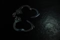 Police metal real handcuffs on the black background. Crime and robbery, prison concept