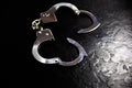 Police metal real handcuffs on the black background. Crime and robbery, prison concept