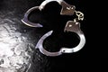 Police metal real handcuffs on the black background. Crime and robbery, prison concept