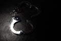 Police metal real handcuffs on the black background. Crime and robbery, prison concept