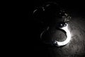 Police metal real handcuffs on the black background. Crime and robbery, prison concept